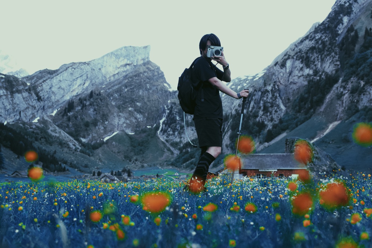 A mountain portrait with a camera in a flower field